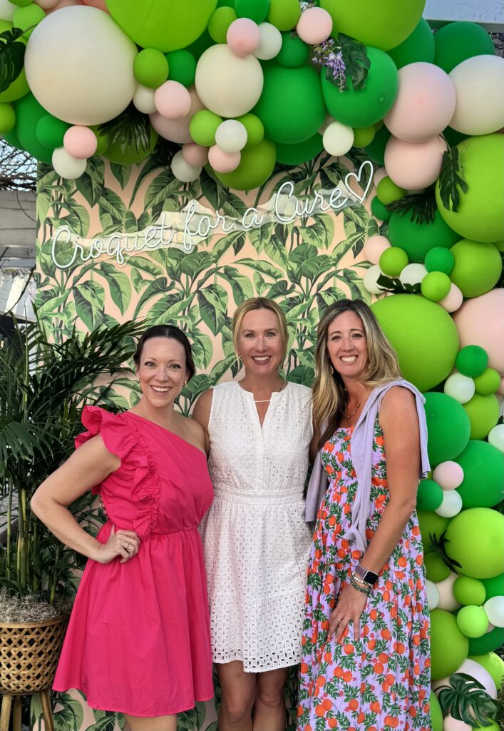 Three women with the croquet for a cure backdrop